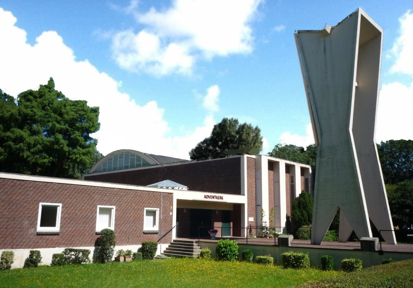 De Adventkerk aan de Hengelolaan, met de ingang naast de herkenbare witte toren