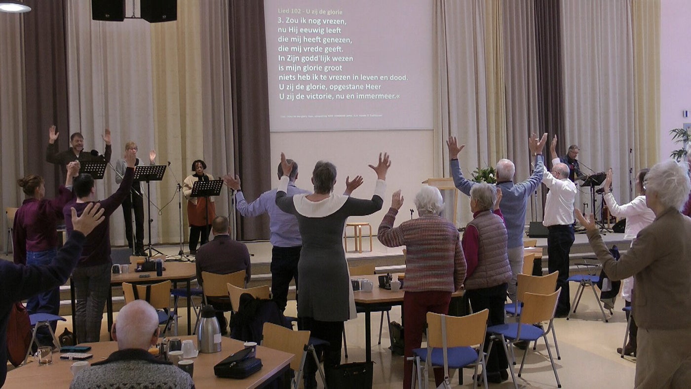 Gemeenteleden zingen samen tijdens een dienst in de Adventkerk